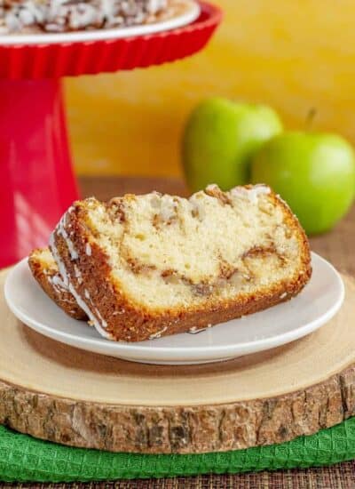 apple bread with apples and a red cake stand behind it