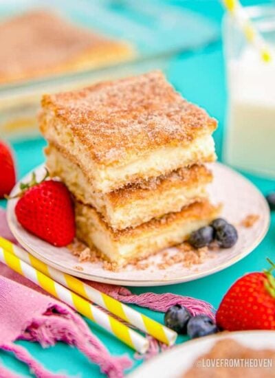 a stack of cheesecake bars topped with cinnamon and sugar