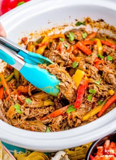 Fajitas in a white crockpot.