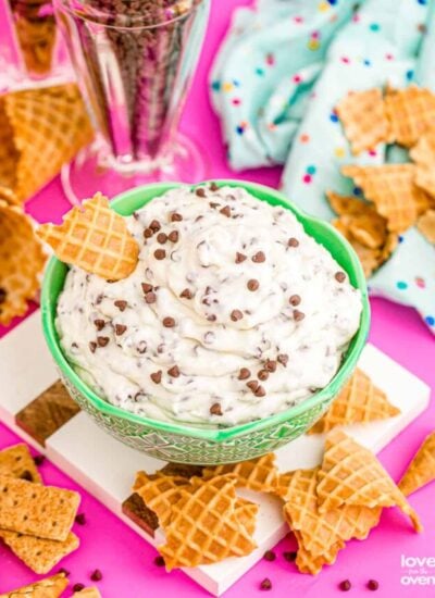 cannoli dip on a colorful table surrounded by waffle cones