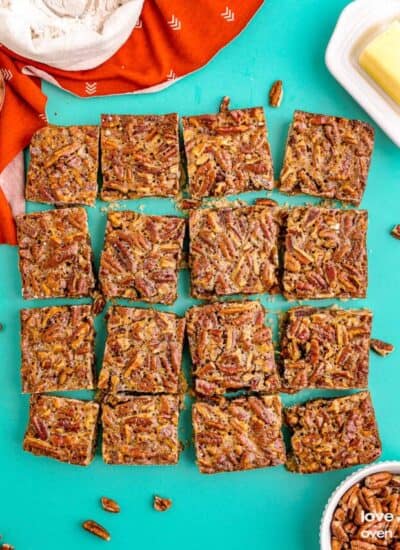 pecan pie bars cut into squares on a blue table