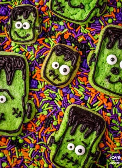 A bunch of halloween cookies on colorful sprinkles.