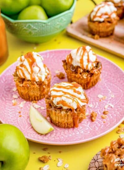 mini caramel apple cheesecakes on a pink plate