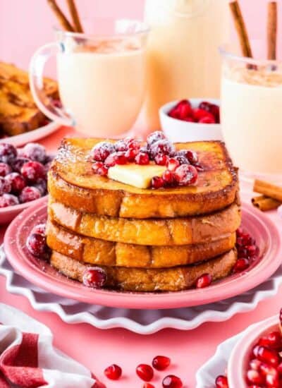 A stack of eggnog french toast on a pink plate.