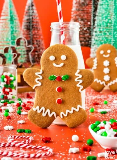 A gingerbread man cookie leaning on a small milk bottle