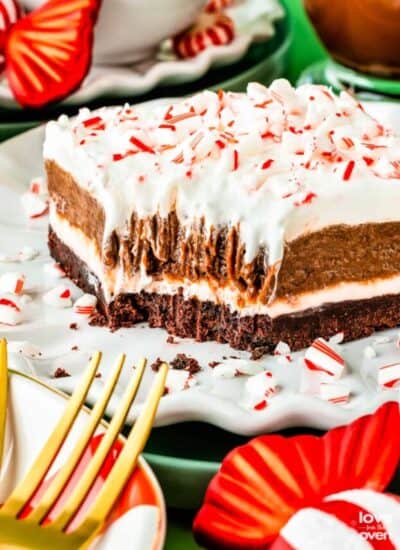 A slice of peppermint striped delight surrounded by Christmas decorations.