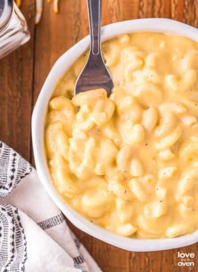 a fork in a bowl of macaroni and cheese