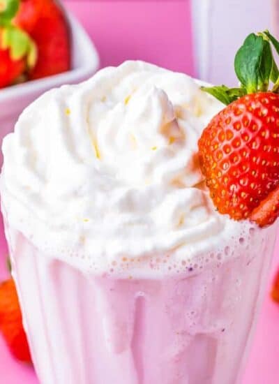 a strawberry milkshake with a strawberry on the side of it