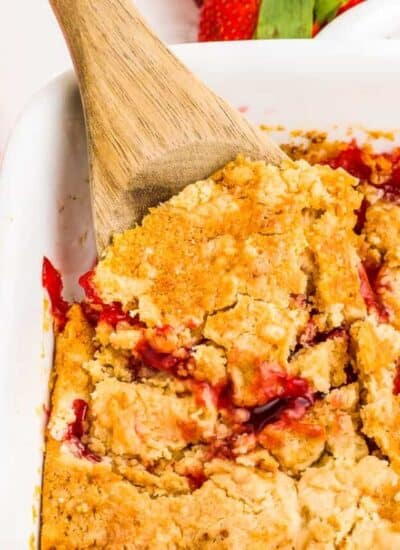 a spoon taking out a scoop of strawberry dump cake