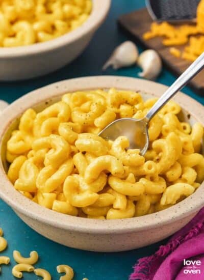 a bowl of butternut squash mac and cheese on a blue background