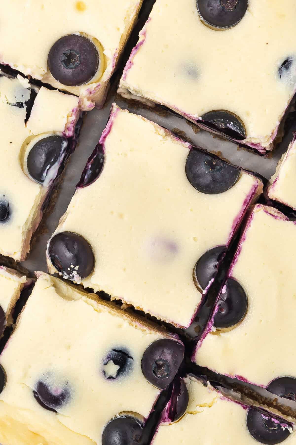 An overhead photo of blueberry cheesecake bars cut into slices.