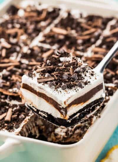 A slice of chocolate lush being taking out of a white pan.