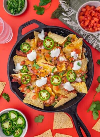 A cast iron skillet with pulled pork nachos in it