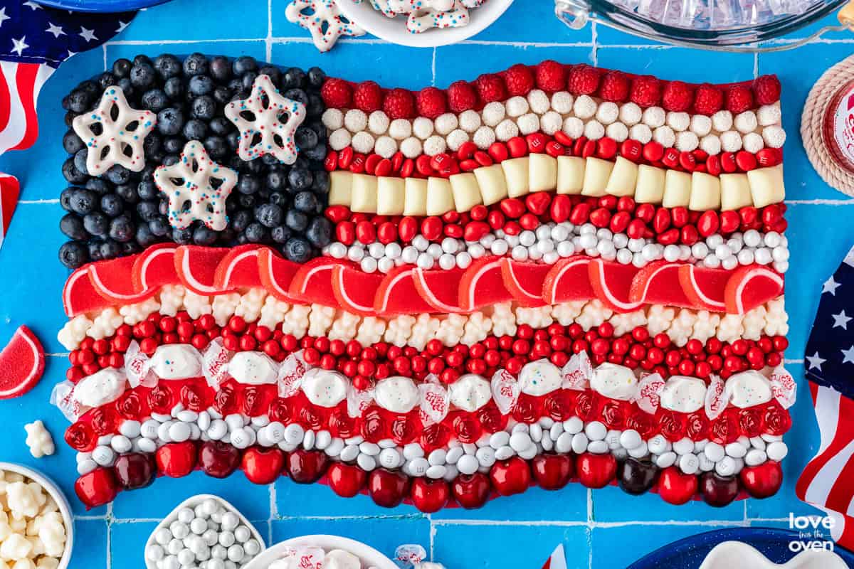An american flag candy board made with red, white and blue candy and fruit