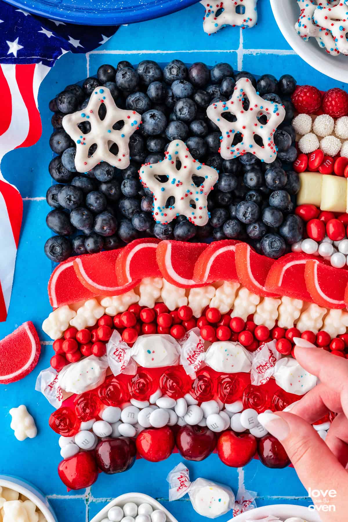 a hand putting candy on a red white and blue flag candy board