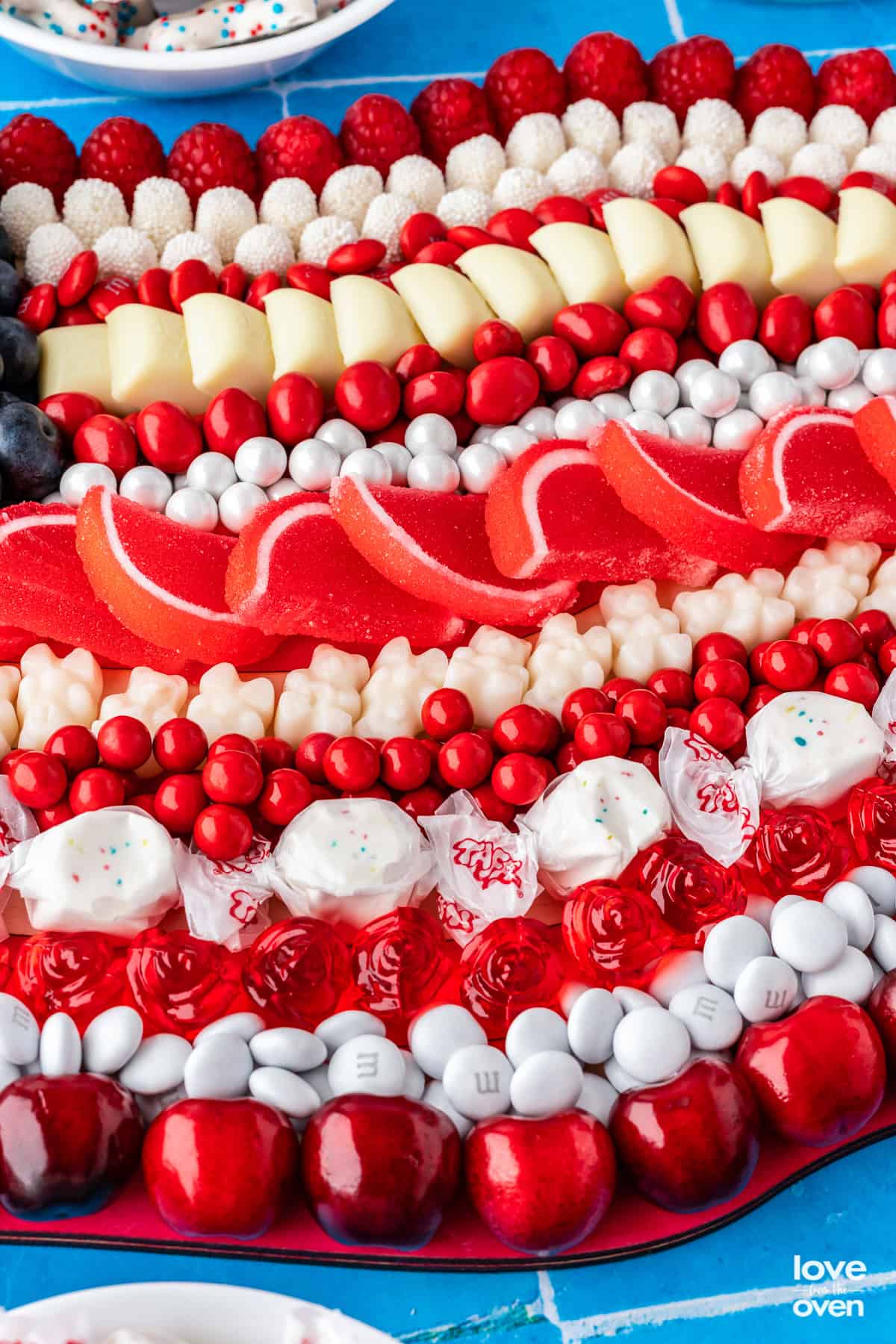 An up close photo of a charcuterie board made with red, white and blue candy to look like a flag