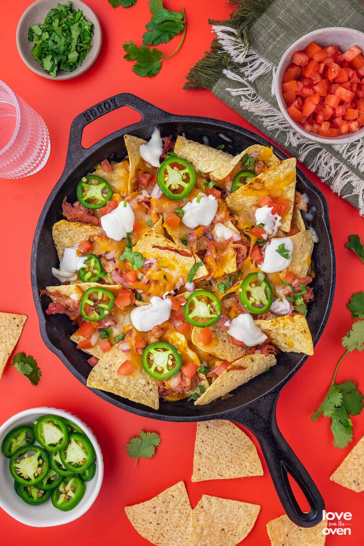 A cast iron skillet with pulled pork nachos in it