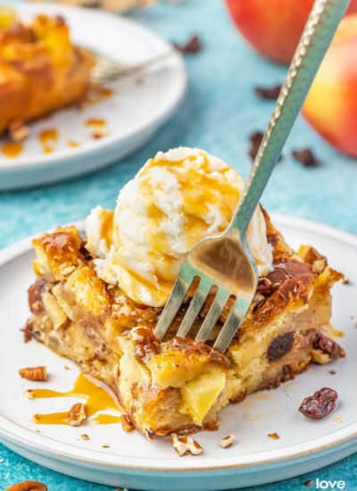 A fork grabbing a bite of apple bread pudding