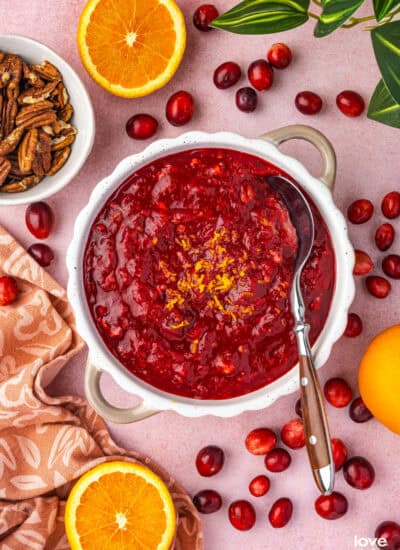 A bowl of cranberry orange relish surrounded by ingredients.