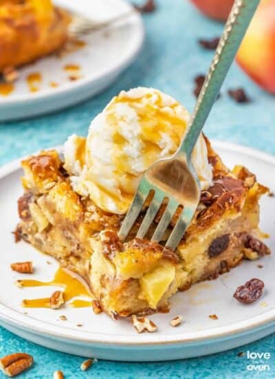 A fork grabbing a bite of apple bread pudding