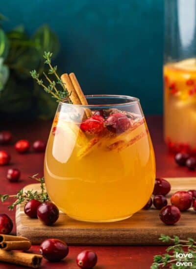 A glass of apple cider sangria with a blue background