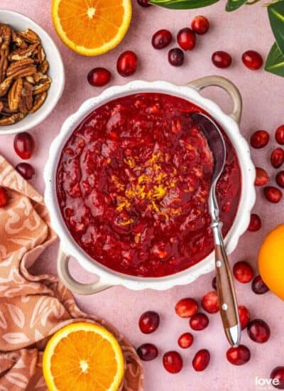 A bowl of cranberry orange relish surrounded by ingredients.