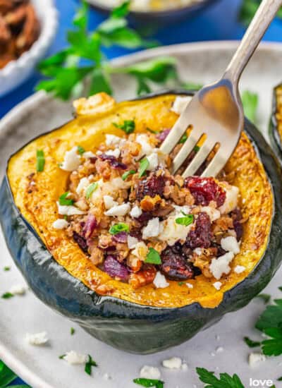 A fork in a baked and stuffed acorn squash.