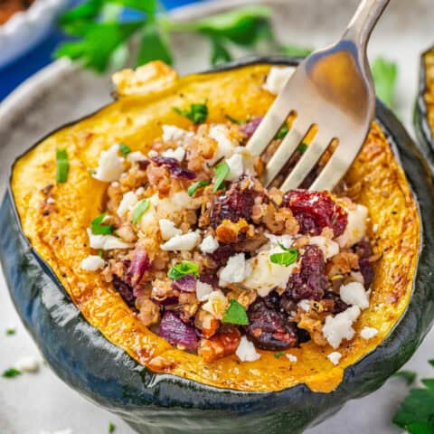 A fork in a baked and stuffed acorn squash.